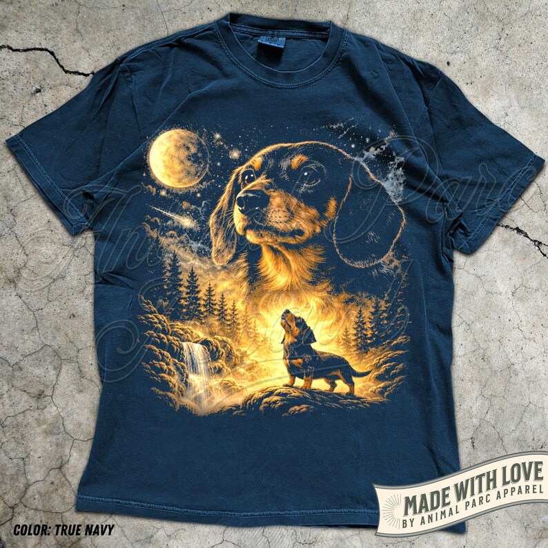 May include: True navy blue t-shirt featuring a detailed illustration of a dachshund dog under a full moon, with a forest and waterfall scene. The design includes the text "MADE WITH LOVE BY ANIMAL PARC APPAREL" and "COLOR: TRUE NAVY".