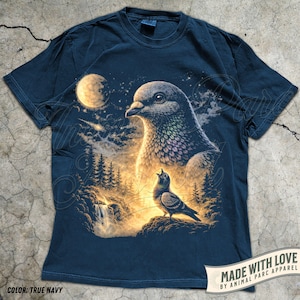 May include: True navy blue t-shirt featuring a detailed illustration of two pigeons in a nighttime forest scene with a full moon. The design includes a waterfall and trees, with the text "MADE WITH LOVE BY ANIMAL PARC APPAREL" on a banner.