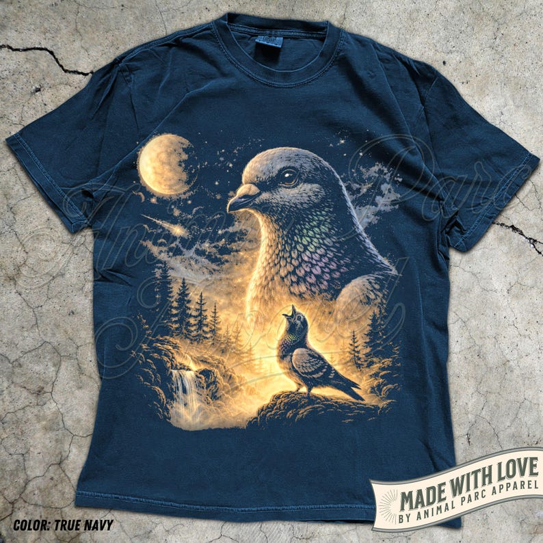 May include: True navy blue t-shirt featuring a detailed illustration of two pigeons in a nighttime forest scene with a full moon. The design includes a waterfall and trees, with the text "MADE WITH LOVE BY ANIMAL PARC APPAREL" on a banner.