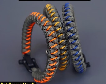 Puede incluir: Tres pulseras de paracord con un diseño de nudo de serpiente. Las pulseras son grises con detalles en naranja, amarillo y azul. ¡Consigue la promoción ahora! Descuento del 30 al 45%.