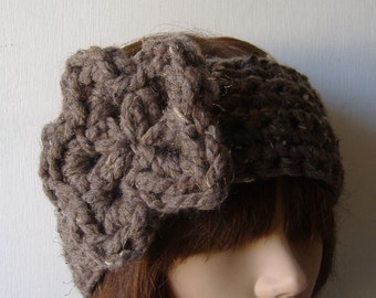 May include: A brown crocheted headband with a large bow on top. The headband is made with a chunky yarn and has a soft, cosy feel.