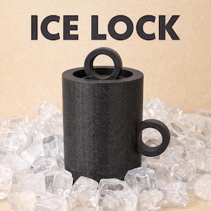 以下が含まれることがあります： 黒い円筒形のマグカップ。取っ手と円形の蓋が付いており、太字の黒い文字で「ICE LOCK」と書かれています。 マグカップは透明な氷に囲まれています。