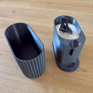 以下が含まれることがあります： リブ付きのデザインと蓋が付いた灰色のプラスチック容器。蓋には小さなスコップと容器の中に白い粉が入っています。