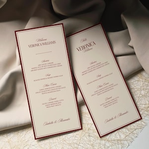Peut inclure: Deux élégants cartons de menu avec un fond crème et une bordure bordeaux. Les cartes présentent le nom "Veronica Williams" et un menu détaillé avec des entrées, une soupe, un plat principal et des options de dessert. Le texte est dans une police serif élégante.