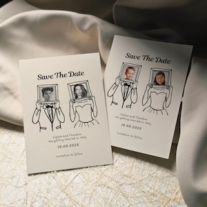 Może przedstawiać: Dwie kremowe karty "Save The Date" z czarnymi ilustracjami. Każda karta przedstawia rysunek osoby trzymającej oprawione zdjęcie. Tekst brzmi "Sophia i Theodore biorą ślub we Włoszech 19.09.2026".