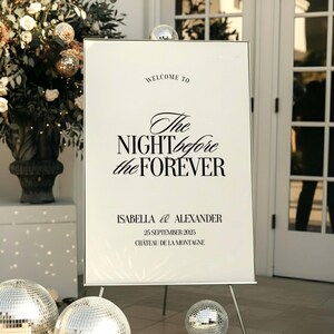May include: A white welcome sign on a metal easel with the text "WELCOME TO The NIGHT before the FOREVER". Below the text are the names "ISABELLA & ALEXANDER" and the date "25 SEPTEMBER 2025". The sign is decorated with disco balls and floral arrangements.