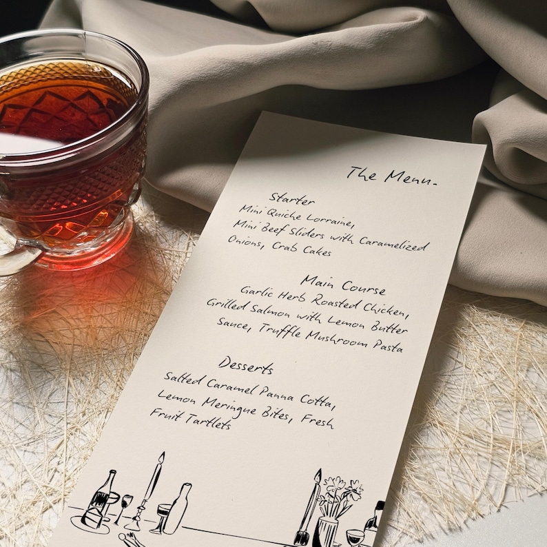 May include: A menu card with handwritten text, featuring starters, main courses, and desserts. A glass teacup with a dark liquid sits to the left. The menu includes dishes like mini quiche, roasted chicken, and salted caramel panna cotta.