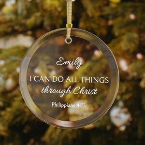 May include: A clear glass Christmas ornament with the text "Emily I can do all things through Christ Philippians 4:13" inscribed on it.