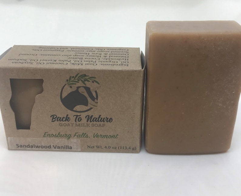 May include: A bar of brown goat milk soap with a label that reads "Back To Nature Goat Milk Soap", "Enosburg Falls, Vermont", and "Sandalwood Vanilla". The soap is packaged in a brown cardboard box with a goat logo.