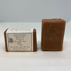 May include: Two bars of brown goat milk soap labeled "Good Stuff Doggie Shampoo Bar Handcrafted Goat Milk Soap" and "Back To Nature Goat Milk Soap Enosburg Falls, Vermont Net Wt. 3.8 oz (107 g)"
