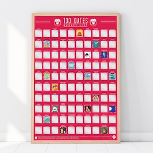 May include: A rectangular 100 Dates Bucket List scratch-off poster in a light wood frame. The poster features a bright pink background with a grid of 100 white squares, some of which are scratched off to reveal colourful illustrations and text.
