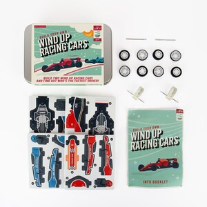 May include: A kit to build wind-up racing cars. The kit includes a metal tin with the words "Build Your Own Wind Up Racing Cars", car parts, wheels, axles, and an info booklet. The car parts are red, blue, black, and orange.