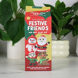 Może przedstawiać: Prostokątne pudełko zestawu do modelowania z gliny samoutwardzalnej Happy Clay Crafts Festive Friends. Opakowanie jest czerwono-zielono-żółte, z ilustracjami bałwana, Świętego Mikołaja, elfa i renifera z gliny oraz nazwą produktu.