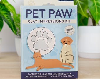 May include: A light blue rectangular box for a Pet Paw Clay Impressions Kit by Gift Republic. The packaging features a white circular clay disc with a paw print, an orange cat, and a tan dog illustration with the text Pawfect for cats & dogs.