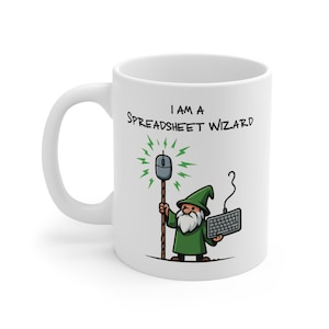 May include: White ceramic mug featuring a cartoon gnome holding a computer mouse and keyboard. The mug has the text "I AM A SPREADSHEET WIZARD". The gnome is depicted in a green outfit.