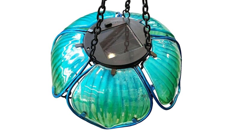 A hanging glass pendant light with a floral design, featuring multiple green glass petals and a black base.