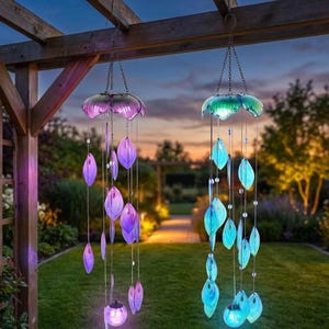 two wind chimes hanging from a wooden structure, each with a unique design and color scheme. The chimes are illuminated with blue and purple lights, creating a captivating and serene atmosphere in the garden.
