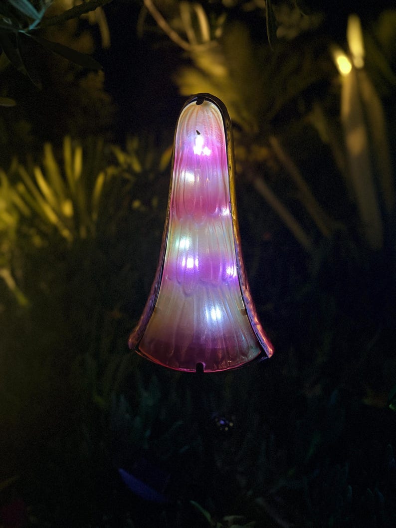 A glowing, illuminated object resembling a flower or plant stands out against the dark background.