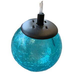A blue glass globe with a black base, featuring a small light fixture attached to it.