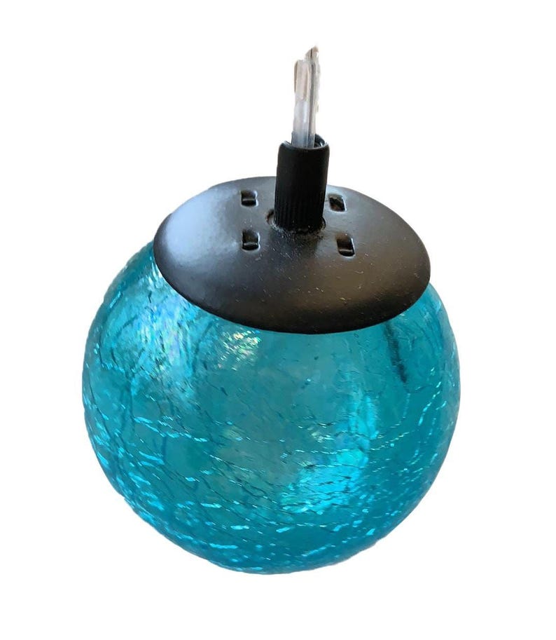 A blue glass globe with a black base, featuring a small light fixture attached to it.