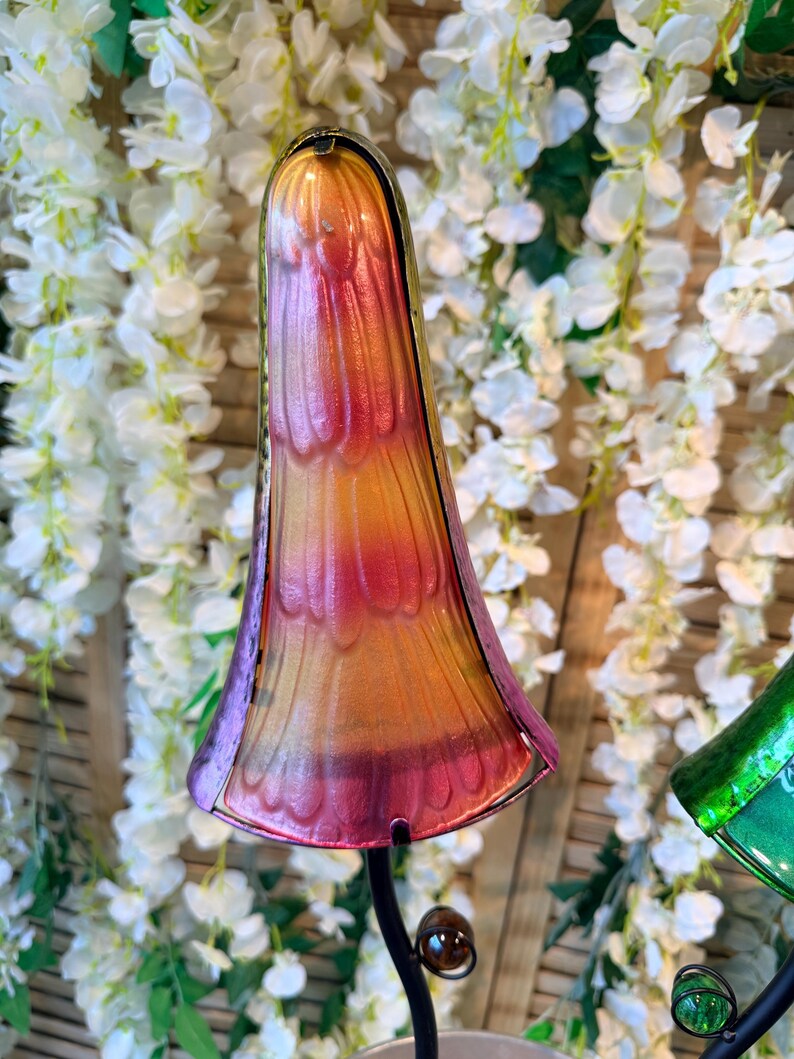 a colorful glass sculpture with a vibrant, multi-colored design, set against a backdrop of white flowers.