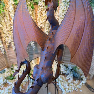 a large, metallic dragon sculpture with intricate details and a metallic appearance.