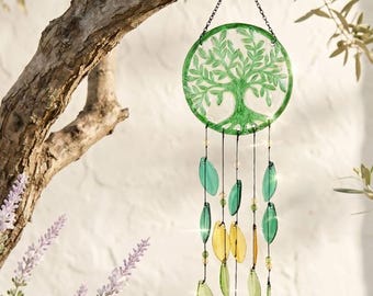 May include: A circular glass suncatcher featuring a green embossed tree design, suspended by a metal chain. Below the disc, multiple strands hang with translucent leaf-shaped glass pieces in shades of green and yellow, accented by small beads.