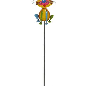 A colorful metal cat figurine sitting on a stick.