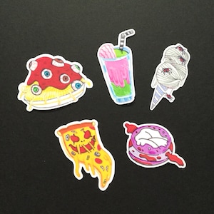 May include: A collection of colorful, cartoon-style food stickers. Includes a plate of spaghetti with eyeballs, a pink and green milkshake, an ice cream cone wrapped in bandages, a pizza slice with a jack-o'-lantern face, and a purple frosted donut.