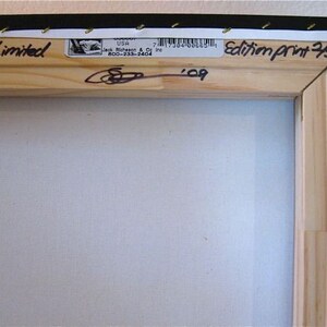 Puede incluir: Primer plano de un marco de madera con un lienzo blanco. El marco tiene una etiqueta que dice "2009 Limited" y "Edition Print 250". La etiqueta tambi&eacute;n incluye una firma y el a&ntilde;o "09".