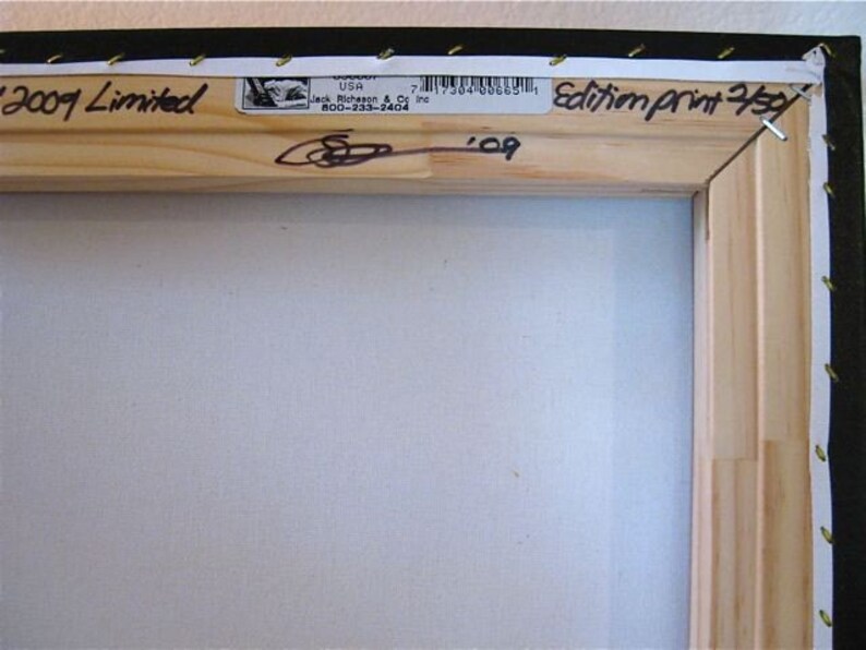 Puede incluir: Primer plano de un marco de madera con un lienzo blanco. El marco tiene una etiqueta que dice "2009 Limited" y "Edition Print 250". La etiqueta tambi&eacute;n incluye una firma y el a&ntilde;o "09".