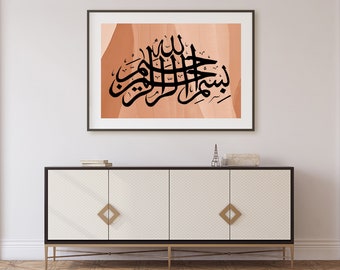 Könnte beinhalten: Ein gerahmter Druck mit einem schwarzen arabischen Kalligraphie-Design auf einem pfirsichfarbenen Hintergrund. Der Druck hängt an einer weißen Wand über einem weißen Schrank mit goldenen Akzenten.