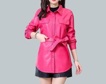 May include: A pink faux leather jacket with a button-up front and a belt. The jacket has two flap pockets on the chest and a long, fitted silhouette.