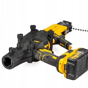 Pode incluir: Um acessório para ferramenta elétrica DeWalt em amarelo e preto com uma carcaça preta texturizada impressa em 3D e vários botões de ajuste. A ferramenta está equipada com uma bateria amarela e preta e uma tira de parafusos lateral.
