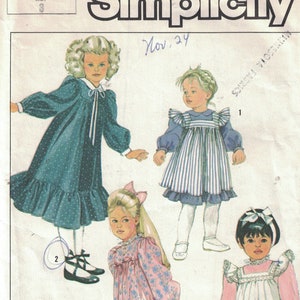 Könnte beinhalten: Simplicity Schnittmuster Nummer 7458 für Mädchenkleider. Das Schnittmuster umfasst drei verschiedene Stile: ein langärmeliges Kleid mit Rüschen am Saum, ein kurzärmeliges Kleid mit Peter-Pan-Kragen und ein ärmelloses Kleid mit Schürze.