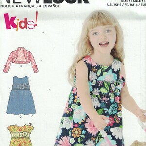 May include: A sewing pattern for a girl's dress and leggings. The pattern includes a floral print dress, a denim dress, a floral print top, a cardigan, and leggings. The pattern is for sizes 1/2-4.