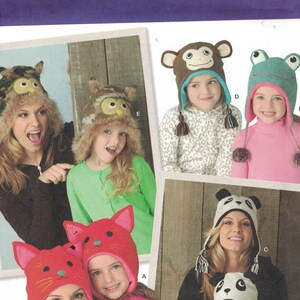 May include: Simplicity sewing pattern 1953 for making children's hats. The pattern includes five different hat designs: a panda, a monkey, a frog, an owl, and a cat. The pattern is for sizes S-L/S-L.