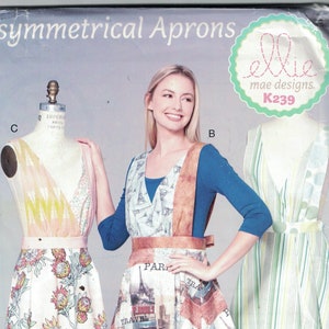 May include: Three asymmetrical apron patterns with different designs. The aprons are made of fabric with various patterns, including floral, travel-themed, and striped. The pattern is called "Ellie mae designs. K239".