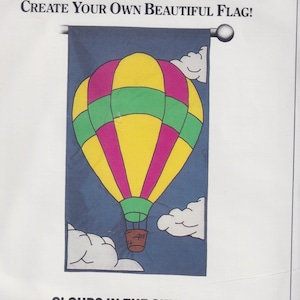 Könnte beinhalten: Ein Nähmuster für eine Heißluftballon-Flagge. Das Muster enthält Anweisungen für eine 71 x 124 cm große Flagge und benötigt 7/8 Yard türkisfarbenen Stoff, 1/4 Yard goldbraunen Stoff, 3/8 Yard weißen Stoff, 3/8 Yard pinkfarbenen Stoff, 3/8 Yard mintgrünen Stoff und 5/8 Yard gelben Stoff.