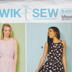 May include: Sewing pattern for two sleeveless dresses. The pattern is called "Kwik Sew" and the pattern number is K4206. The pattern is for misses' sizes XS-S-M-L-XL. One dress is pink and the other is black with white flowers.
