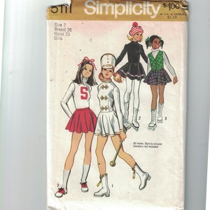Puede incluir: Un patr&oacute;n de costura vintage Simplicity para disfraces de ni&ntilde;as. El patr&oacute;n incluye tres looks diferentes: un atuendo de animadora con una falda roja y un su&eacute;ter blanco, un uniforme de banda de marcha con una falda blanca y ribetes dorados, y un vestido negro con un cuello blanco. El patr&oacute;n es para las tallas 7, con un busto de 66 cm y una cintura de 58 cm.