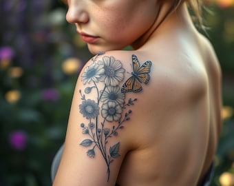 May include: A detailed tattoo of a floral bouquet with daisies and a butterfly on a person's shoulder. The butterfly has orange and black markings. The flowers are in black and white, with detailed shading.