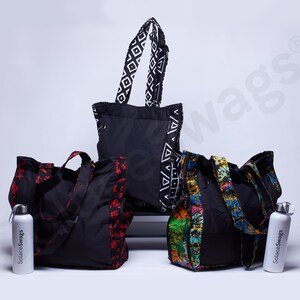 May include: Four black reusable tote bags with different patterned fabric trim. Two of the bags have white water bottles with the text "Solace Swags" printed on them.