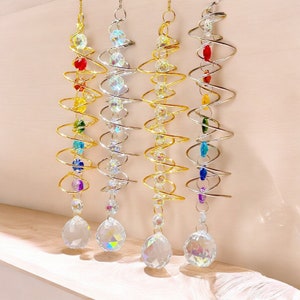 Könnte beinhalten: Vier Kristall-Sonnenfänger hängen von einer Decke. Jeder Sonnenfänger ist eine Spirale aus Metalldraht mit bunten Perlen und einem großen Kristallprisma am unteren Ende.