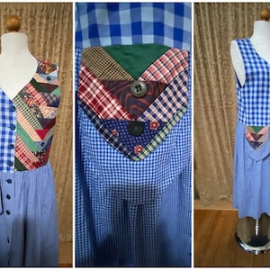 Puede incluir: Un vestido a cuadros azules y blancos con un chaleco patchwork. El chaleco presenta una variedad de telas estampadas en rojo, verde y marrón, con botones negros grandes. El vestido tiene una botonadura frontal y un bolsillo.