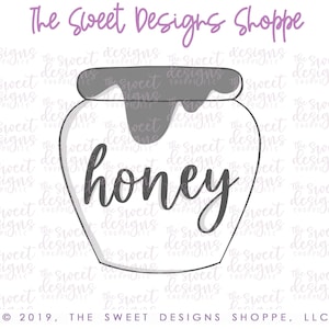 May include: A white ceramic honey jar with a gray lid and the word "honey" written in black cursive script. The jar is decorated with a gray drip design.