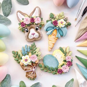 May include: Decorated Easter cookies in the shape of a bunny, carrot, bouquet, and eggs. The bunny cookie has a floral crown. The carrot cookie has a blue bow. The bouquet cookie is wrapped in brown paper. The egg cookies are decorated with flowers.