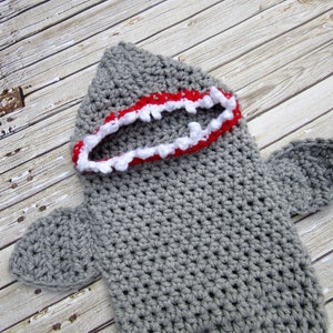 May include: Grey crocheted shark costume with a red and white mouth.