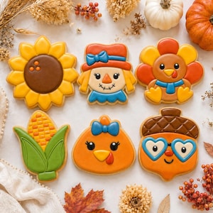 Könnte beinhalten: Sechs verzierte Kekse mit herbstlichen Motiven: eine gelbe Sonnenblume, eine Vogelscheuche mit Hut, ein Truthahn mit orangefarbenen Federn, ein Maiskolben, ein Truthahnkopf mit blauer Schleife und eine Eichel mit herzförmiger blauer Brille.