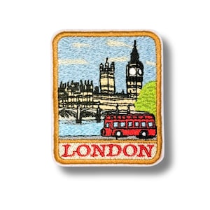 May include: A rectangular embroidered patch featuring a scene of London with the Houses of Parliament, Big Ben, and a red double-decker bus. The sky is light blue with white clouds, and the word LONDON is stitched in red at the bottom.